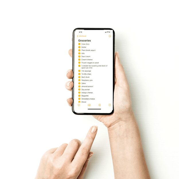 A hand holding a phone with a grocery list