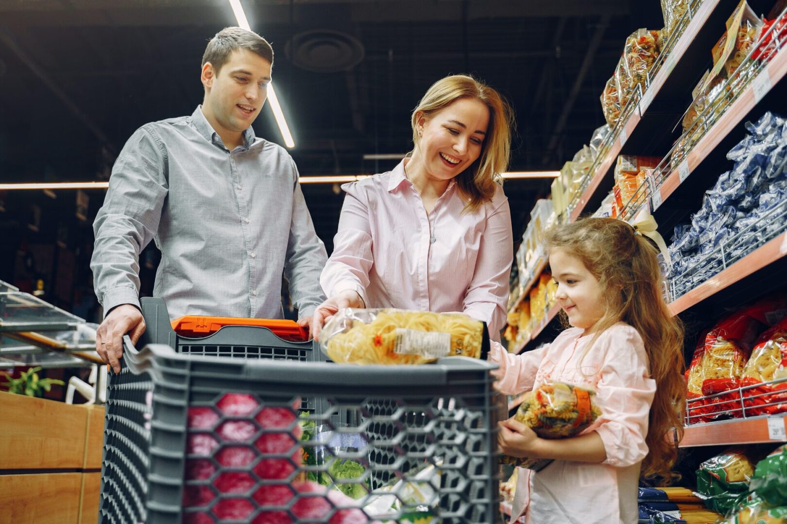 a couple shopping for grocery with their kid